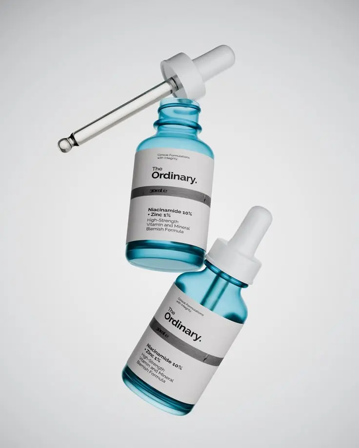 the ordinary niacinamide serum bottles displayed on a soft gradient background.