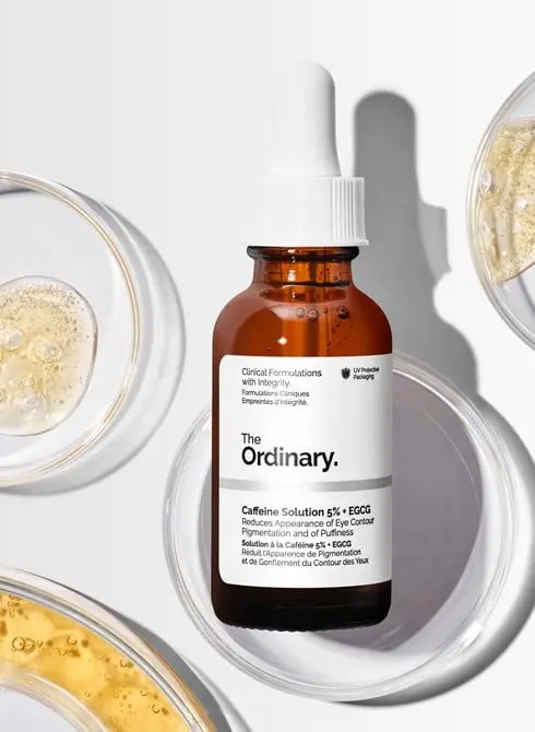 the ordinary caffeine solution 5% + EGCG serum clinical bottle placed on a white background with suitable patterns.